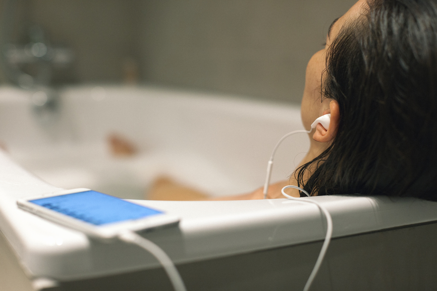 A woman listening to songs in the bath tub